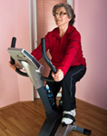 Woman is exercising on an indoor bike to avoid night leg cramps